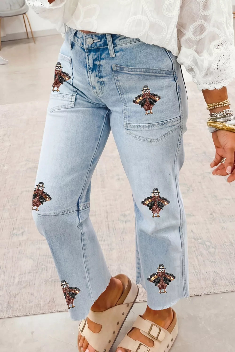Light blue sequin turkey raw-hem ankle jeans, angled front view.