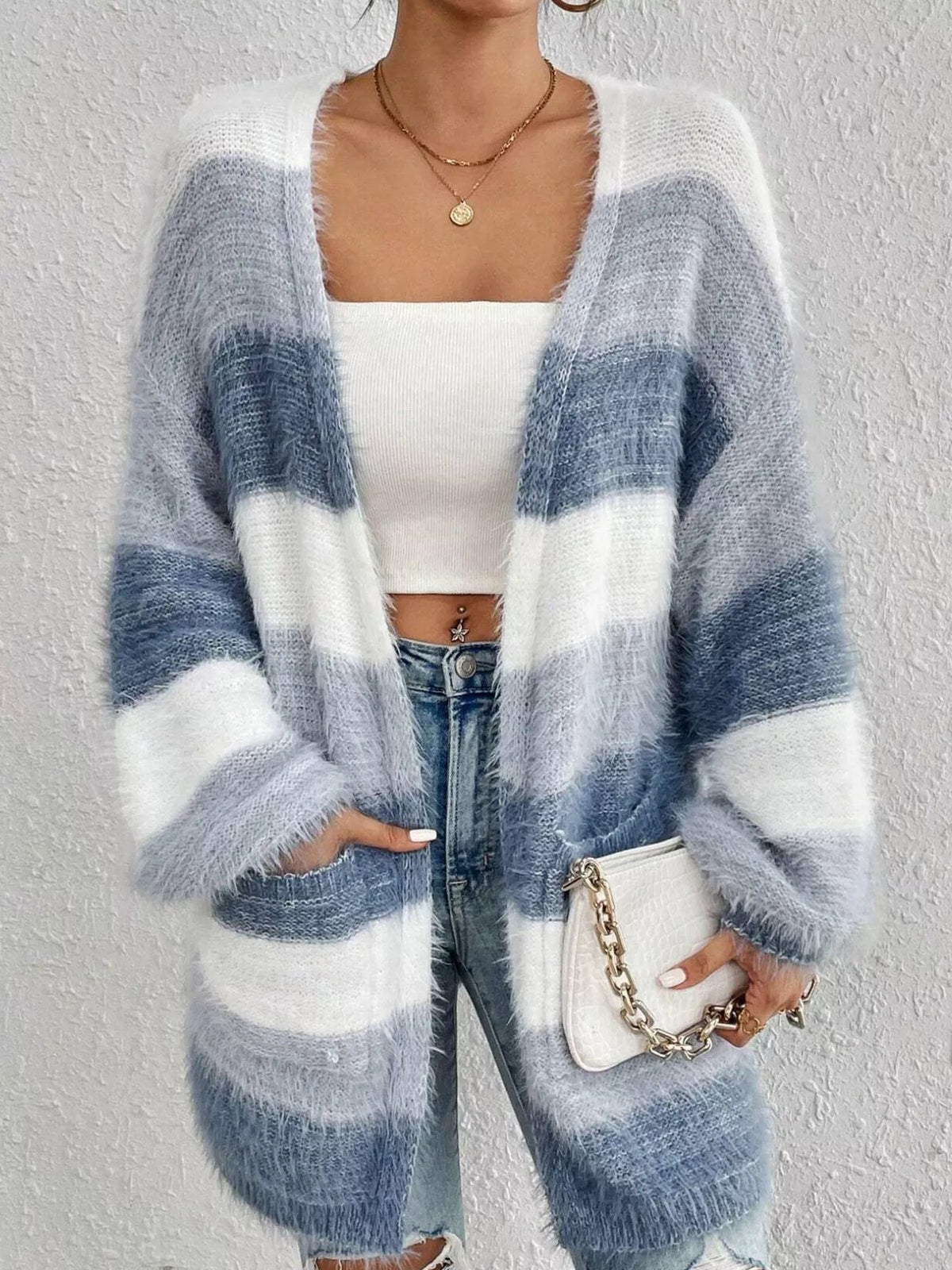 Blue and white striped open-front oversized cardigan, front with hand in pocket.