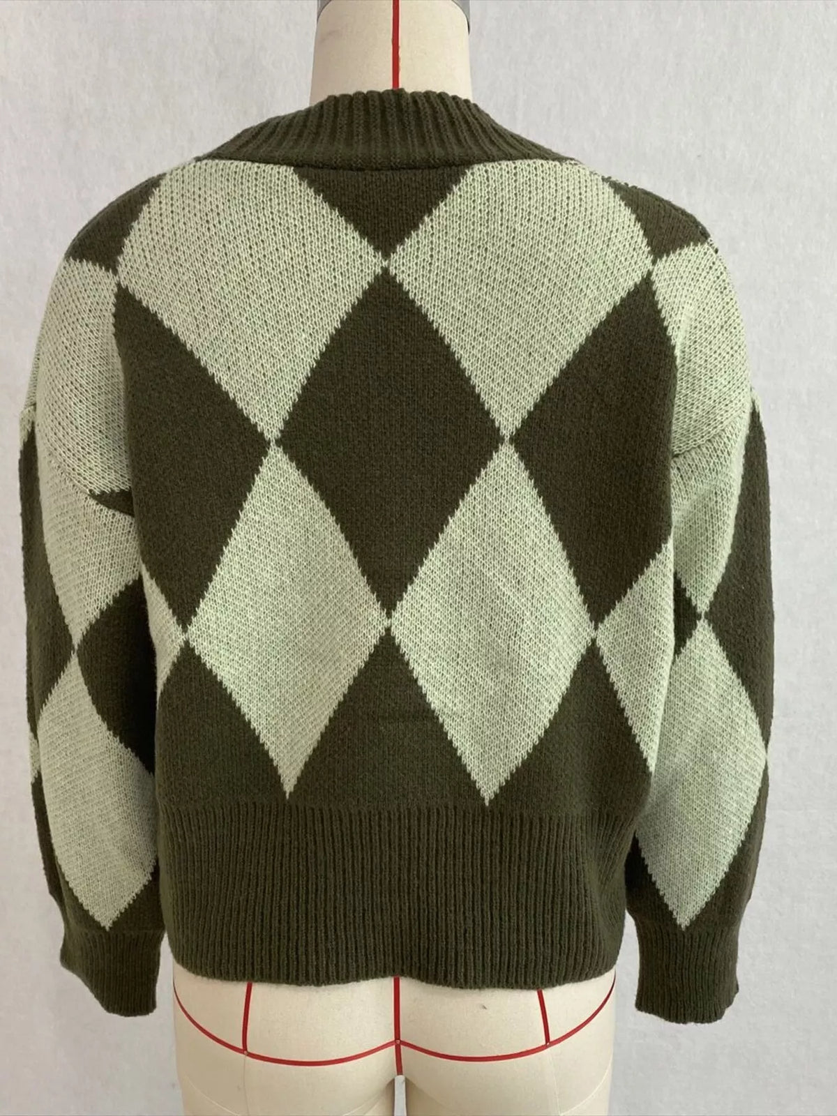 Green argyle v-neck button-front cardigan, back on dress form.