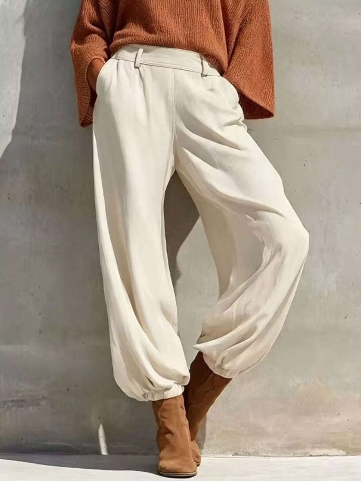 Rust one-shoulder knit top and pants set, white pants front view.