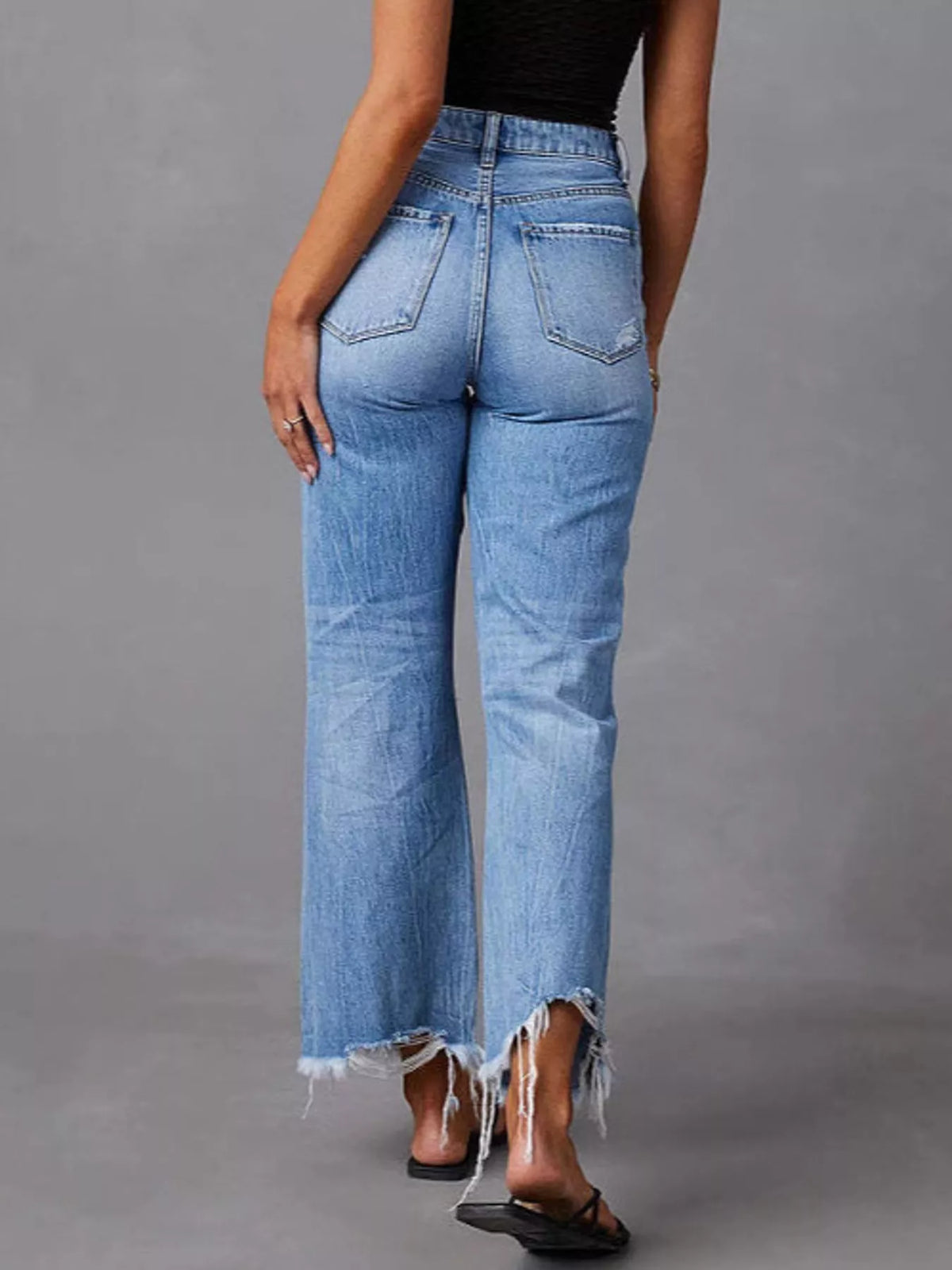 Blue distressed flare jeans — back view
