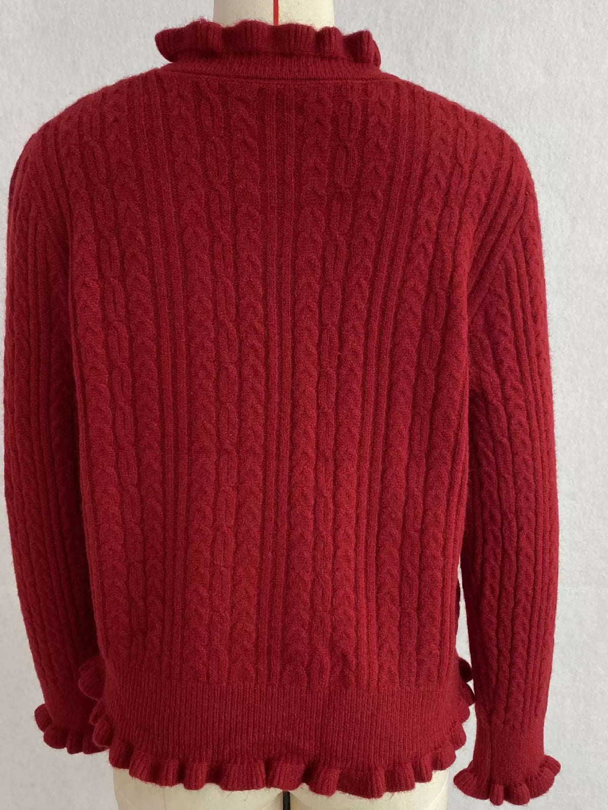 Burgundy cable-knit ruffle-trim cardigan, back on dress form.