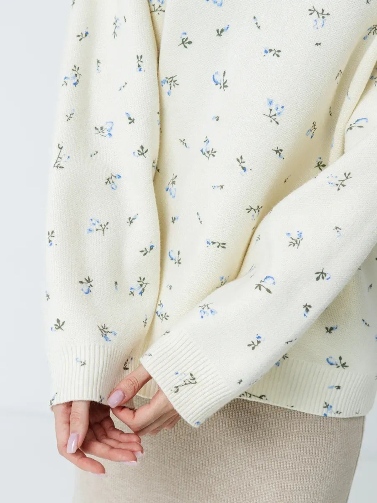White floral dropped-shoulder oversized sweater, sleeve and hem detail.