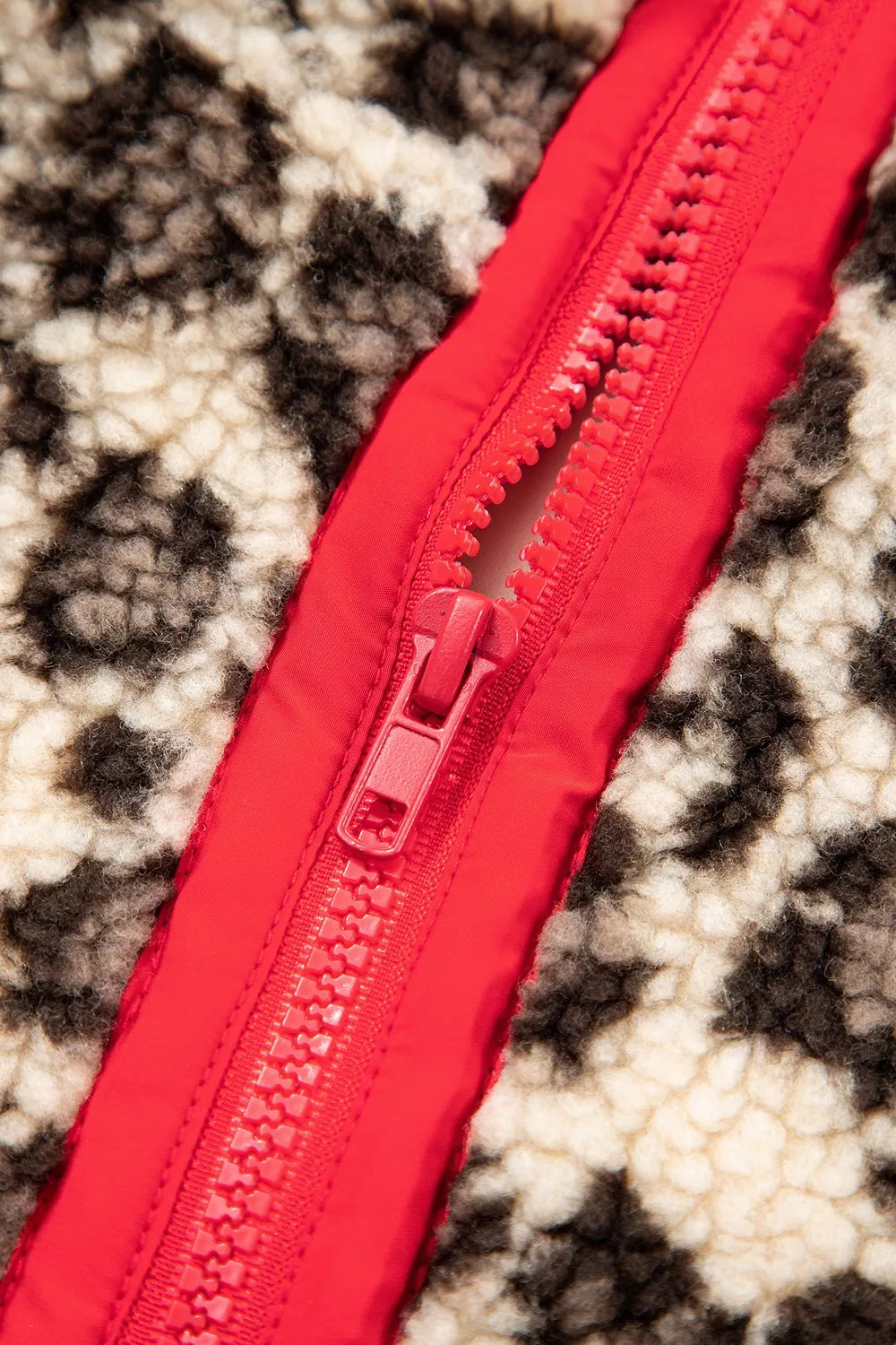 Leopard leopard half-zip sweatshirt with red trim, red zipper close-up.