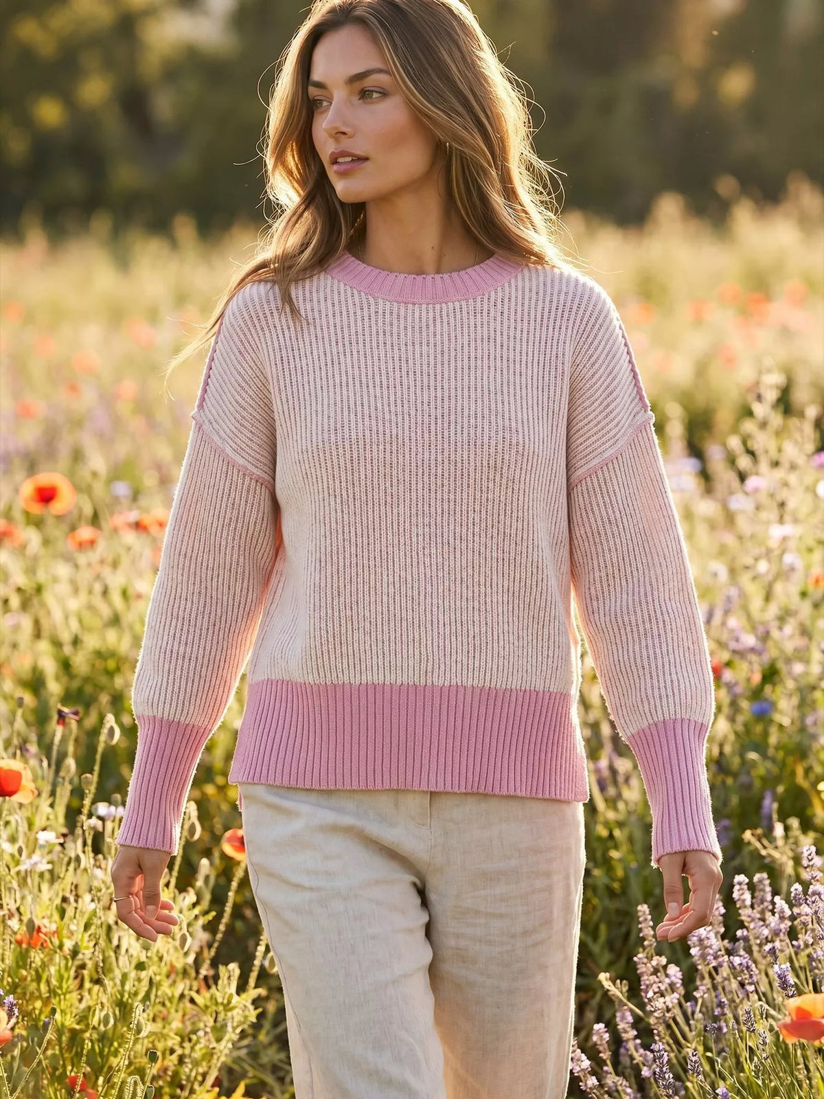 Pink ribbed side-slit sweater with contrast trim, walking front view.