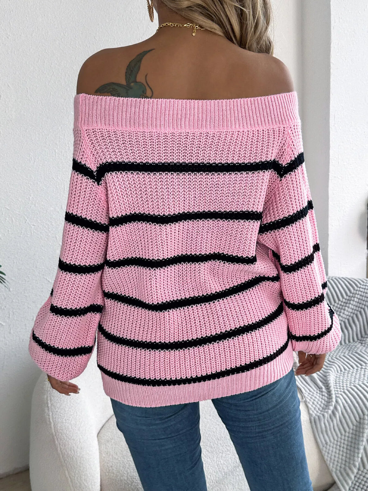 Pink off-shoulder striped sweater, back view.