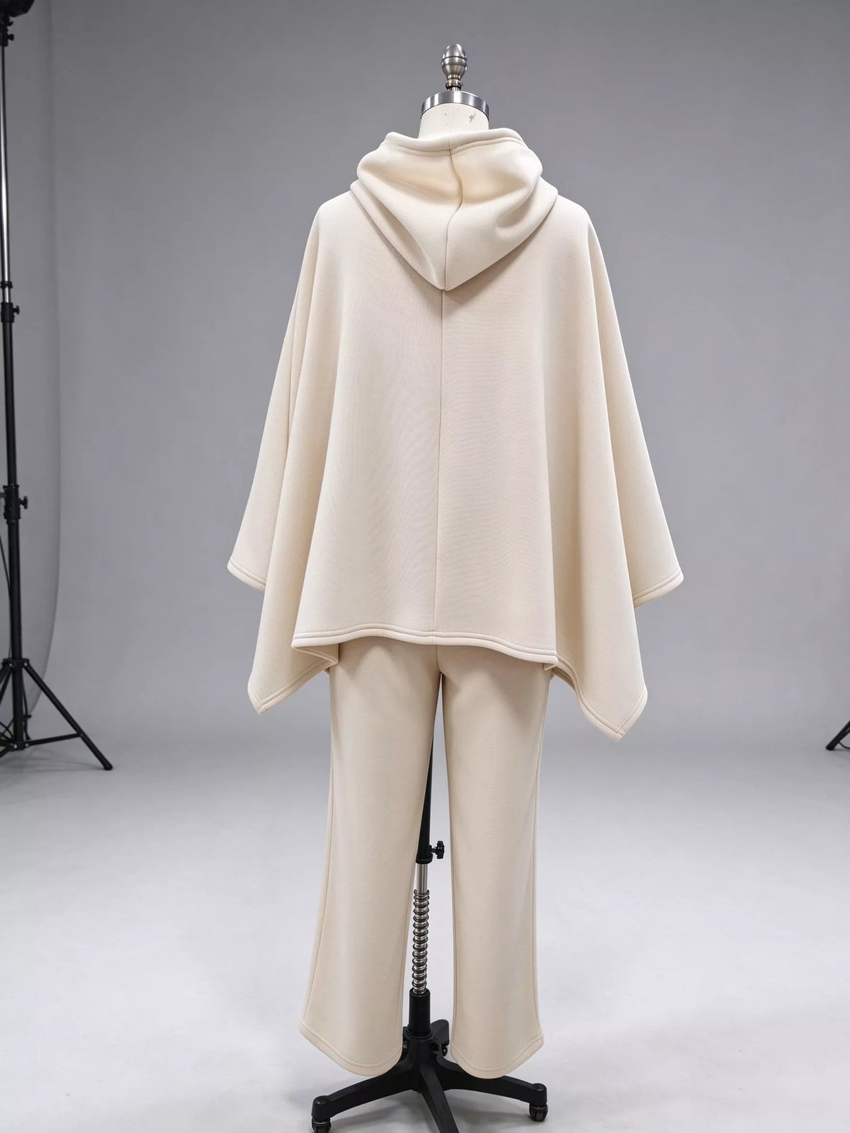 Cream hooded poncho and wide-leg pants set, back on dress form.