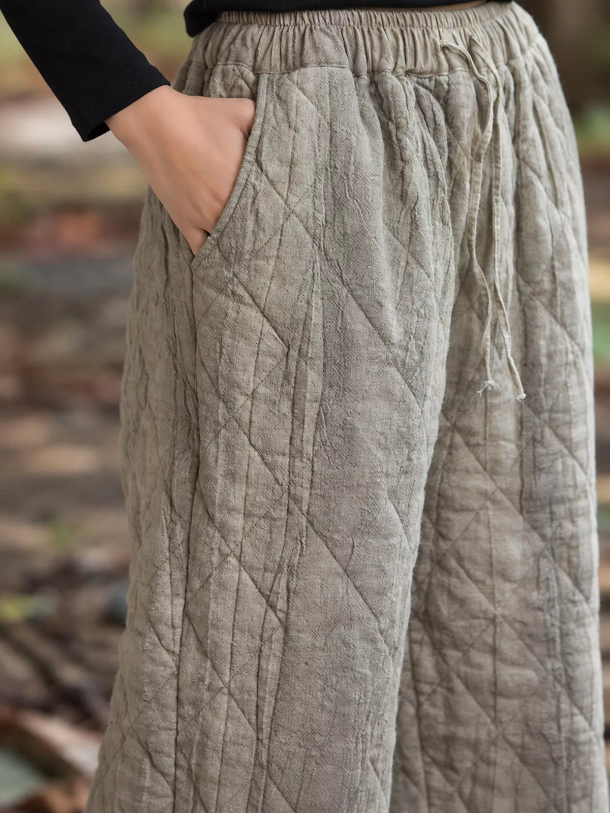 Beige quilted wide-leg pants, elastic drawstring waist, side pocket, and quilted texture