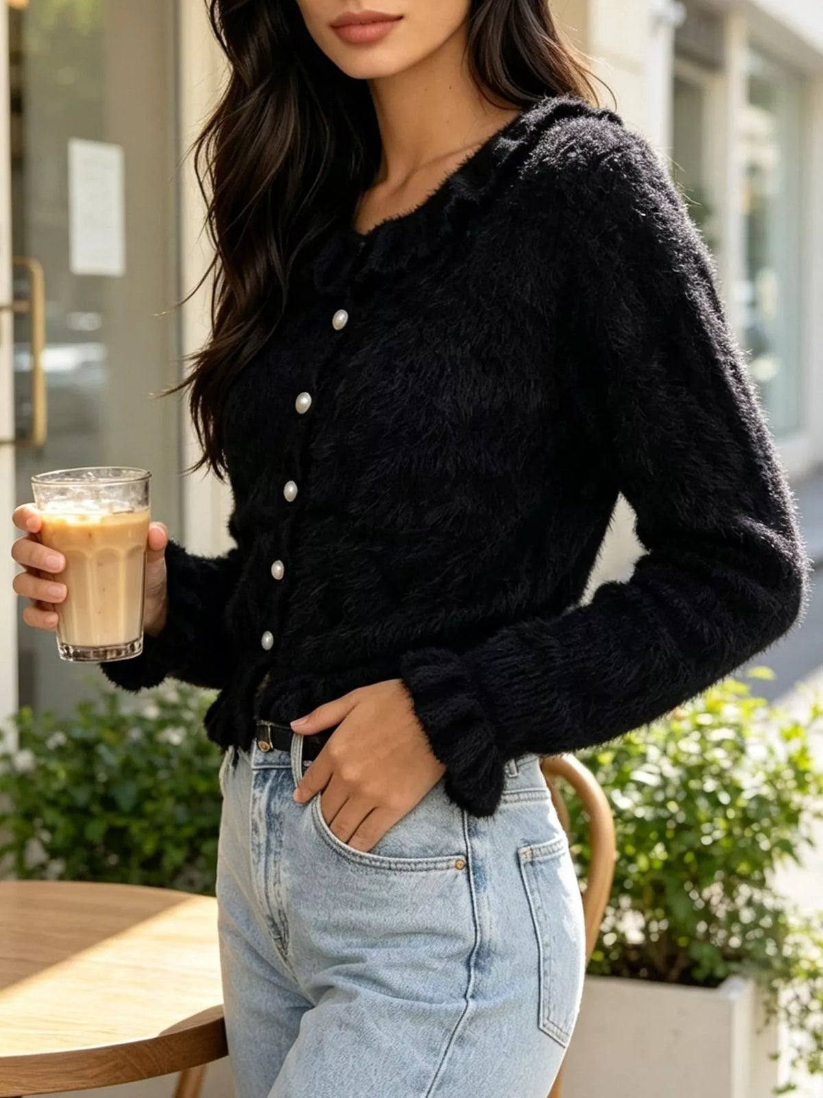 Black fuzzy ruffle-trim button-front cardigan, angled front view.