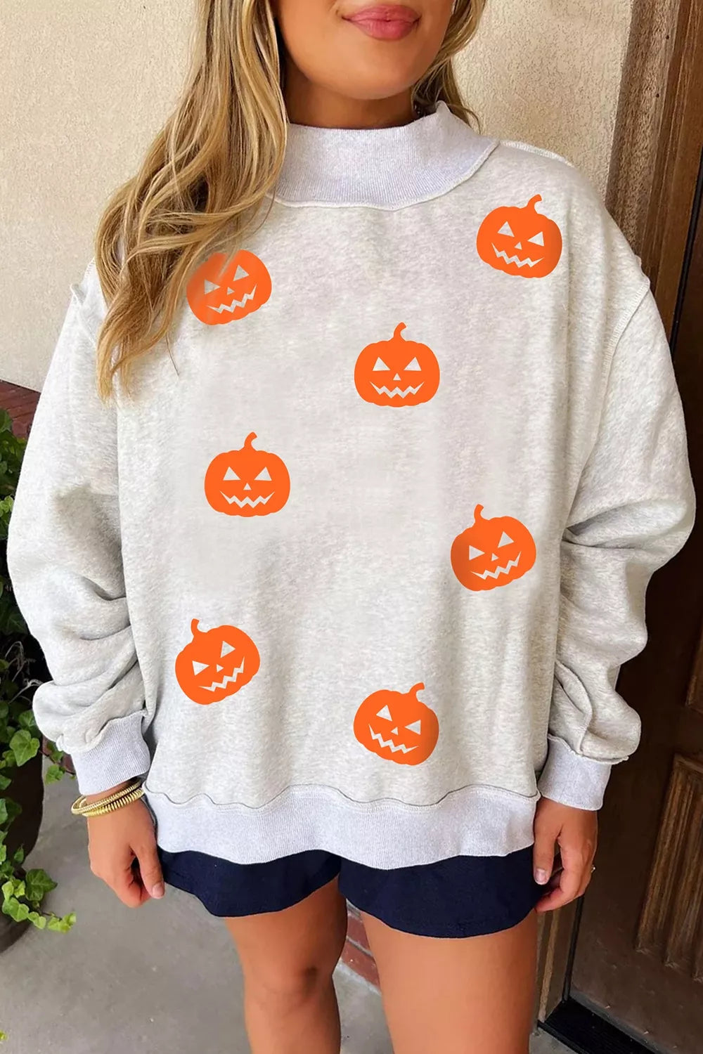 Women's pumpkin face print mock-neck reversible Halloween sweatshirt