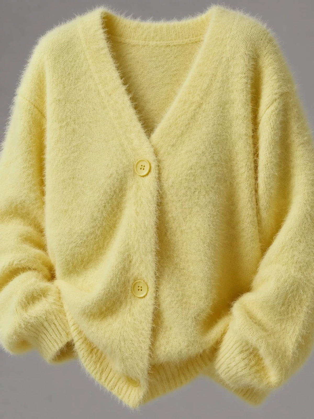 Yellow fuzzy v-neck button-down cardigan, flat front view showing neckline, buttons, and fuzzy knit hem