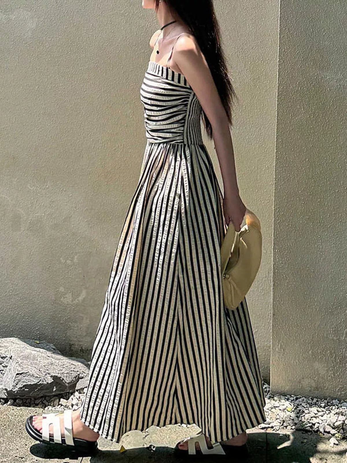 Black and white striped spaghetti strap maxi dress with gathered bodice and pockets, side view