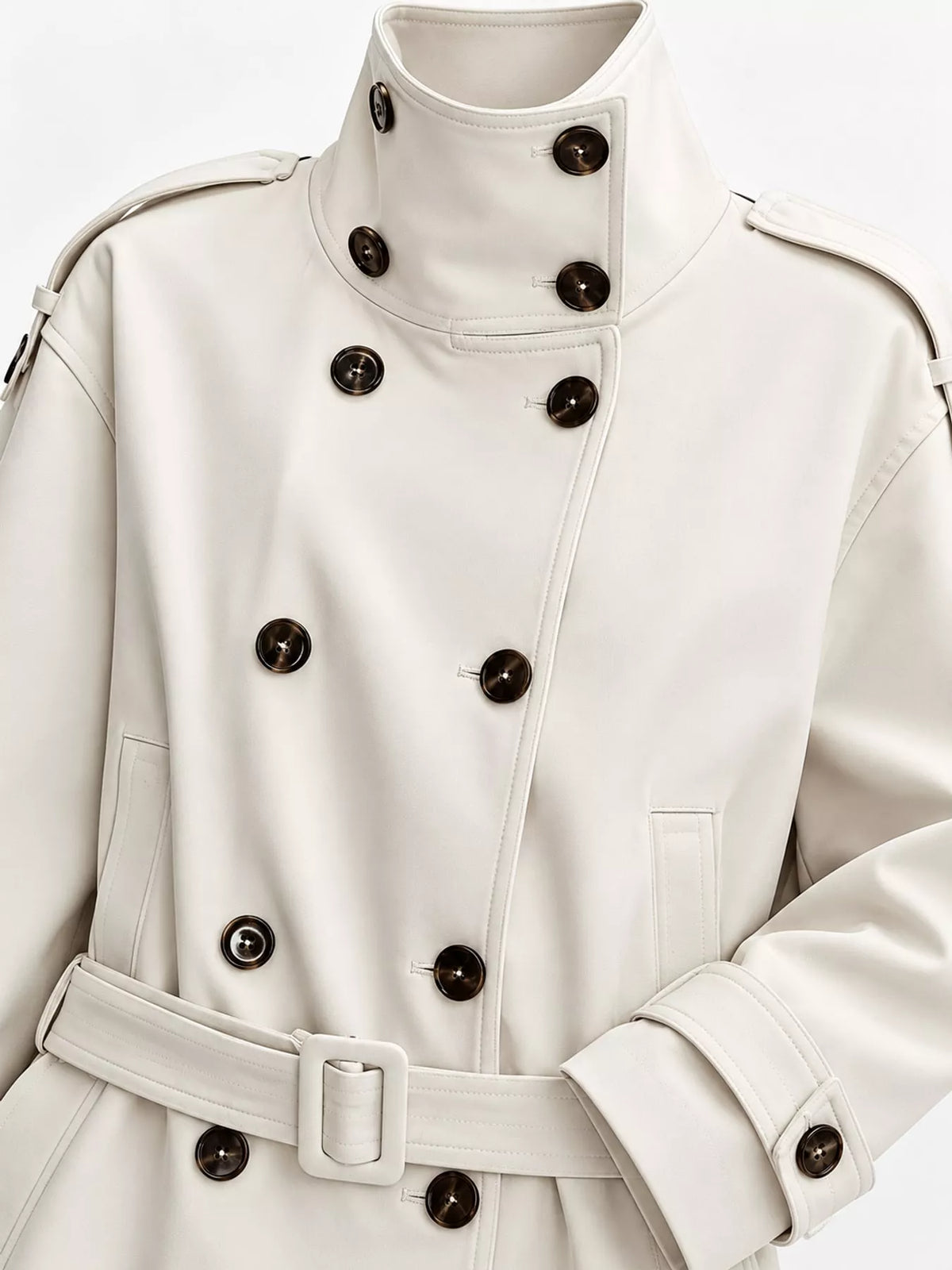 Cream double-breasted high-neck belted trench coat, double-breasted front, collar, shoulder tabs, belt, and cuffs