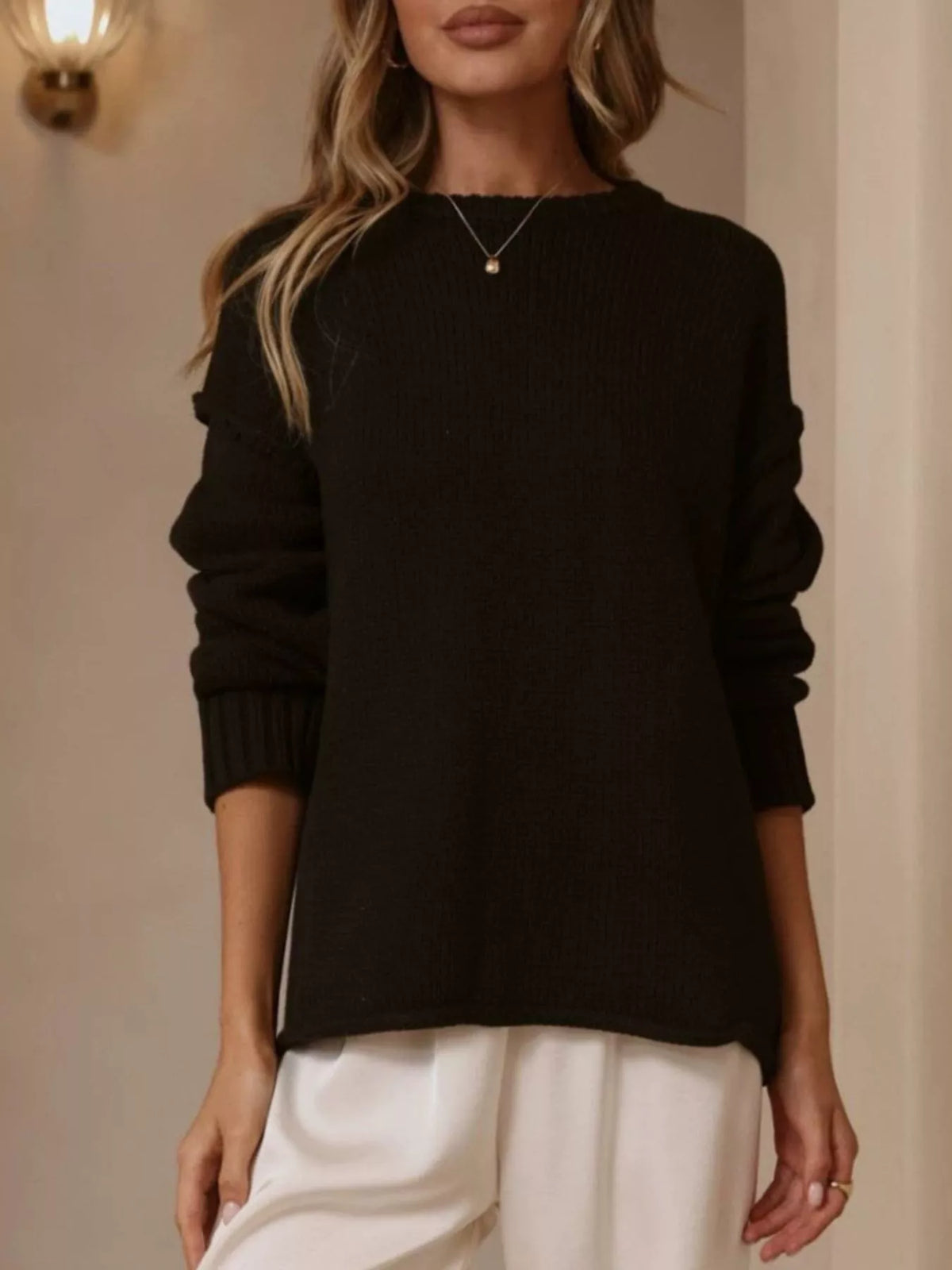 Black crewneck dropped-shoulder sweater, standing front view.