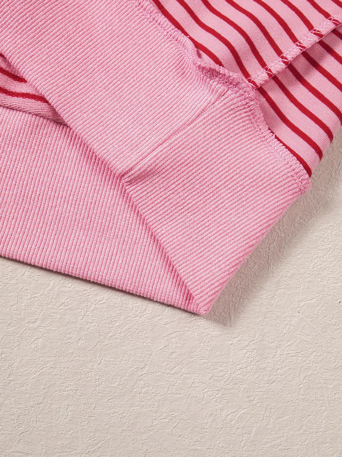 Ribbed hem on pink and red striped striped color-block mock neck sweatshirt