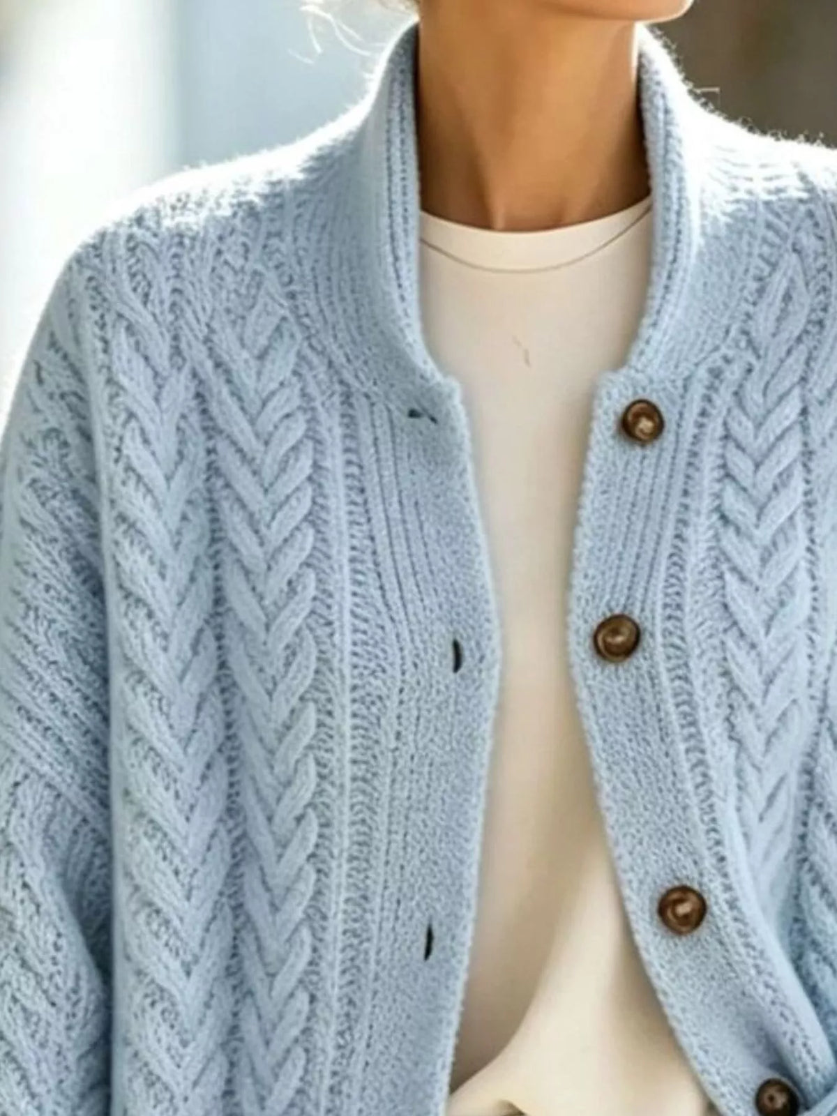 Light blue longline cable-knit button-front cardigan, cable knit and button detail.