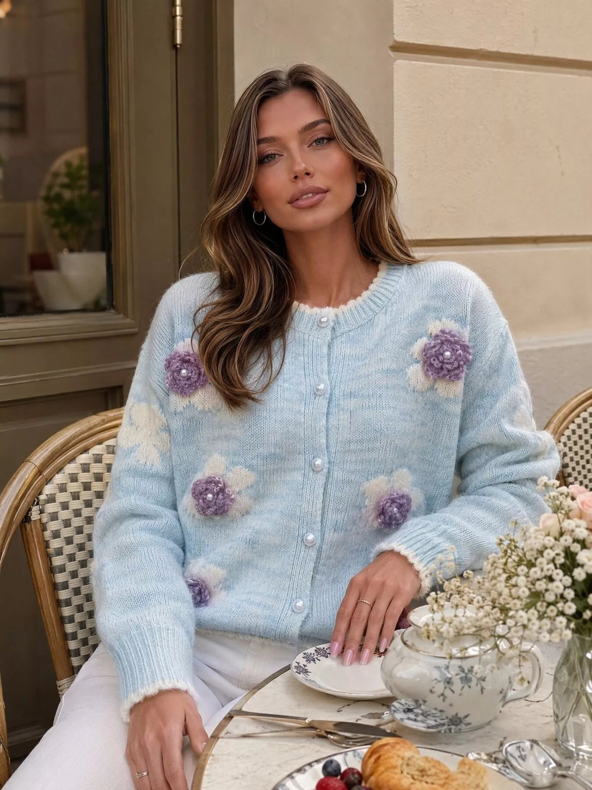 Floral-applique knit cardigan in light blue, seated front view