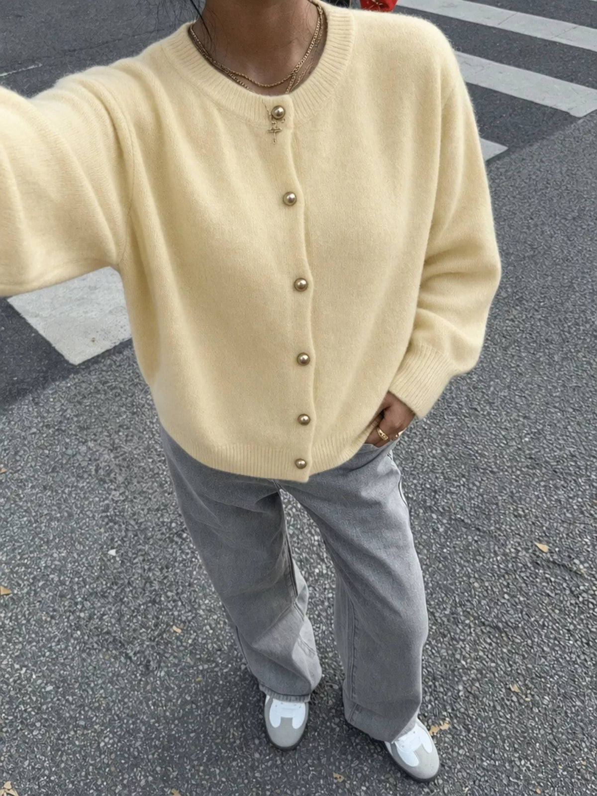 Pale yellow round-neck button-front knit cardigan, front view from above.