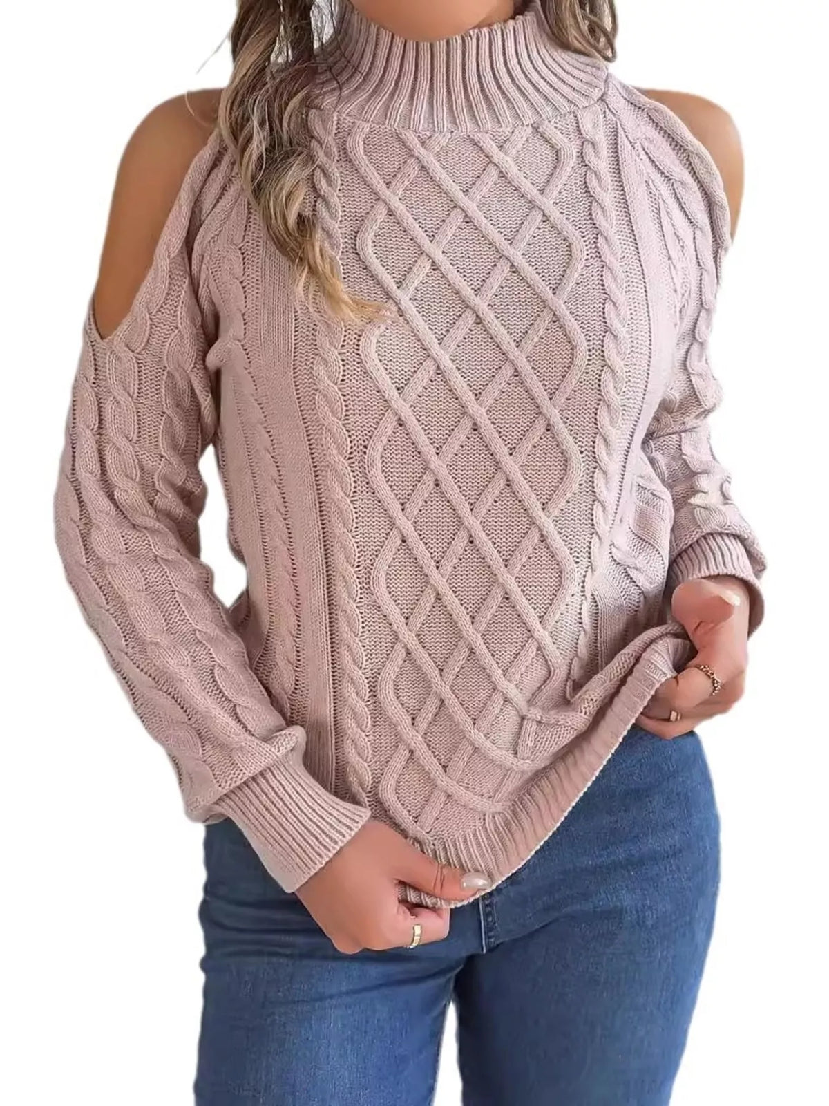 Pink cold-shoulder cable-knit sweater, front holding hem.
