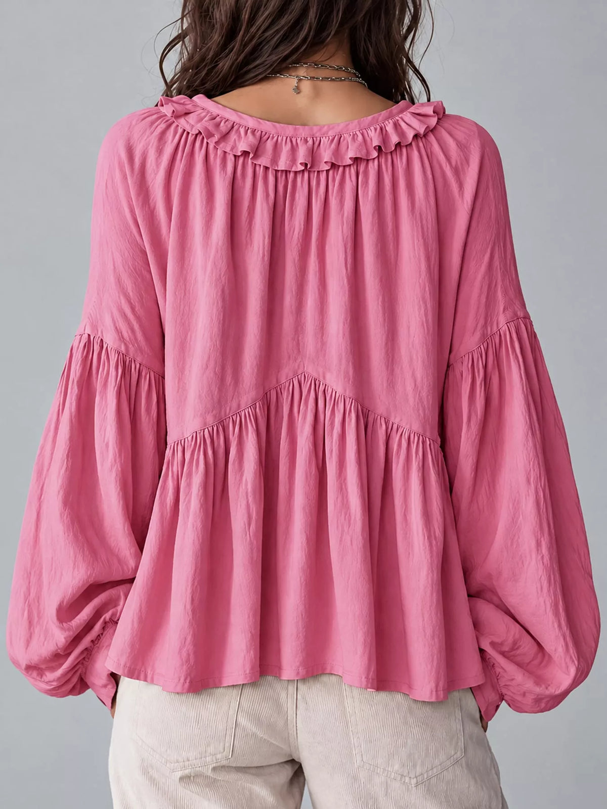 Pink ruffled v neck blouse, back view