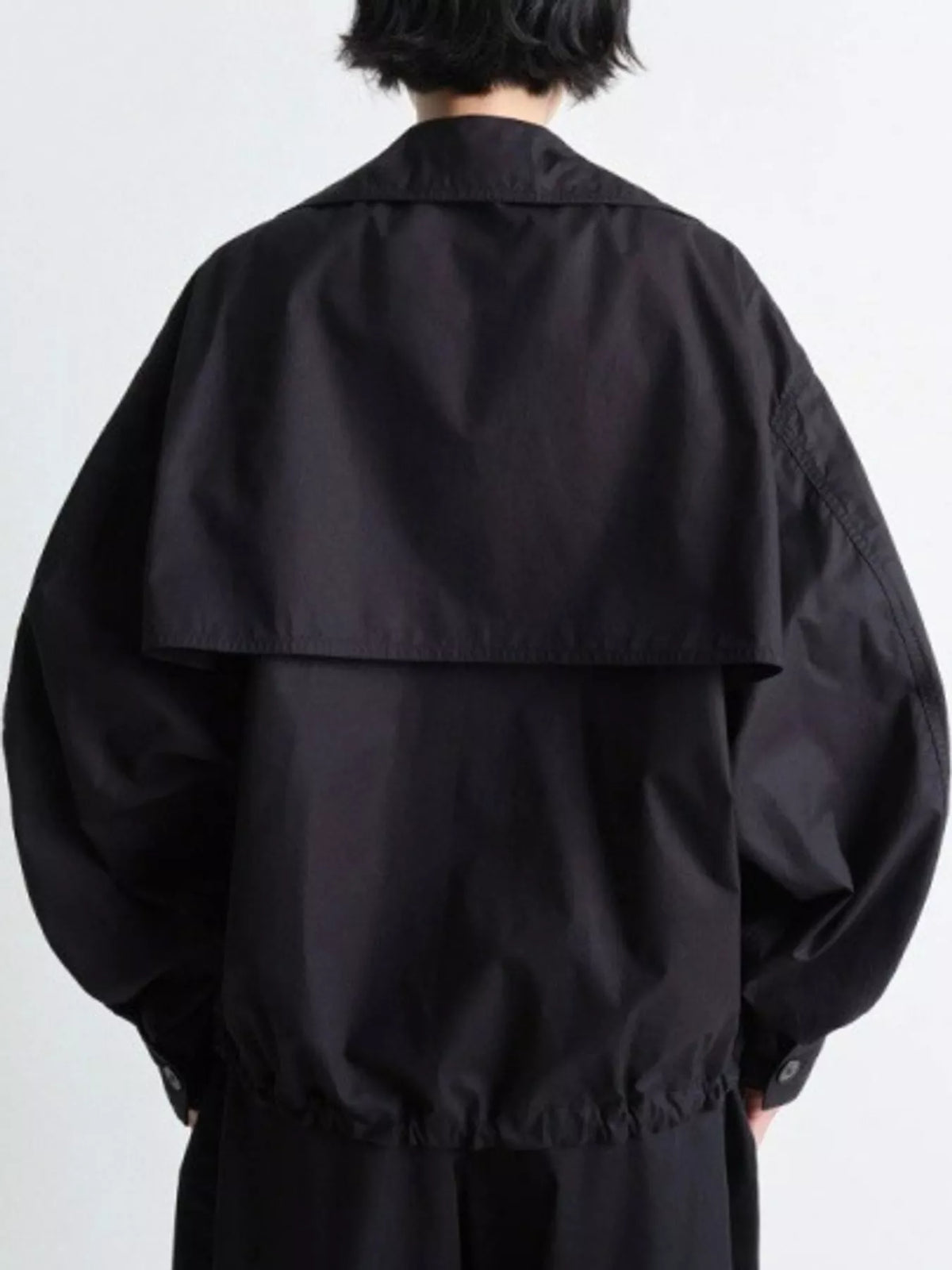 Black double-breasted utility jacket with drawstring hem — back view