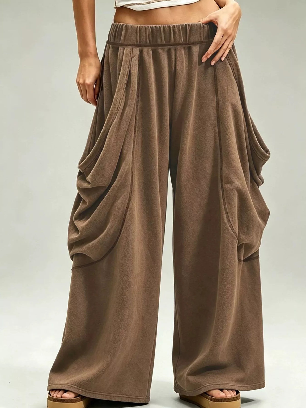 Brown wide-leg cargo pants, front view with hand at waist