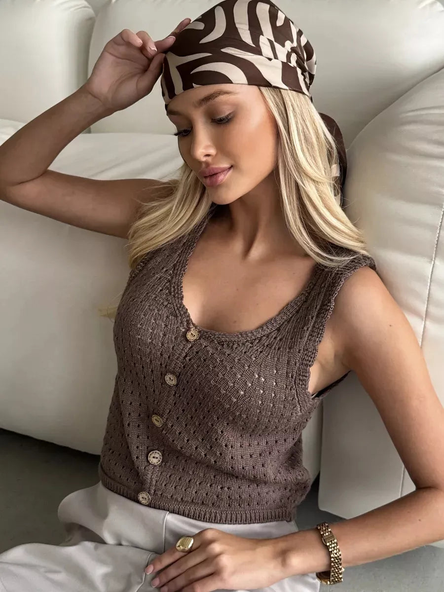 Brown openwork button-detail knit tank top, angled seated view.