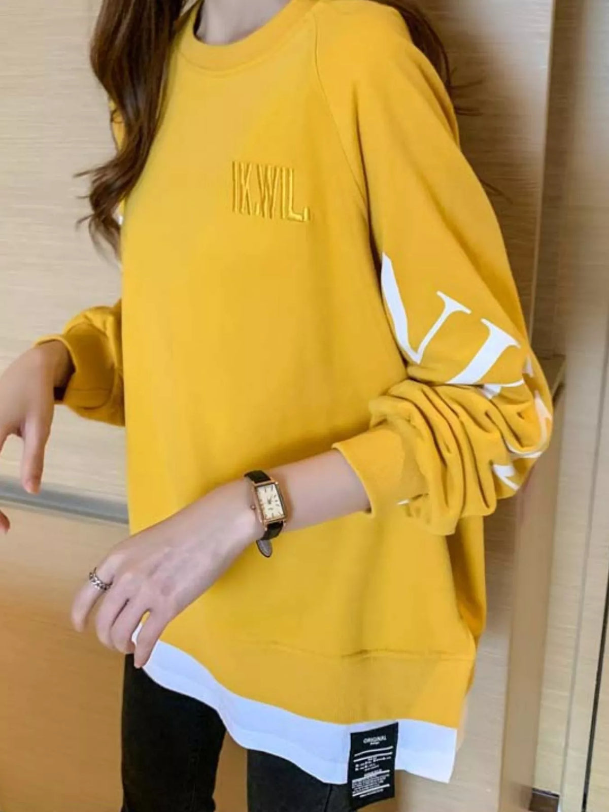Yellow layered-hem sweatshirt with graphic sleeve detail, back view