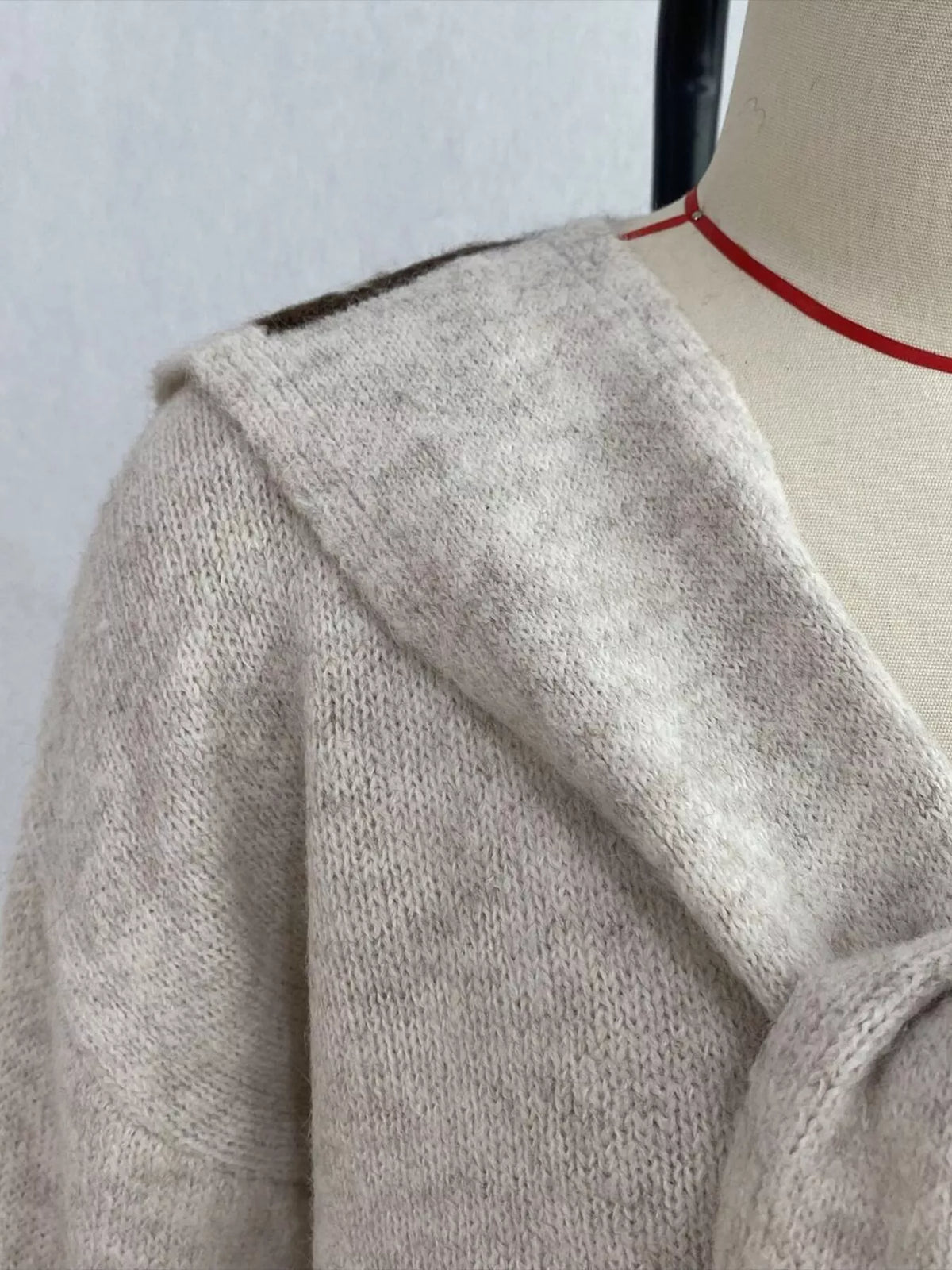 Ivory scarf-detail dropped-shoulder sweater, collar detail.