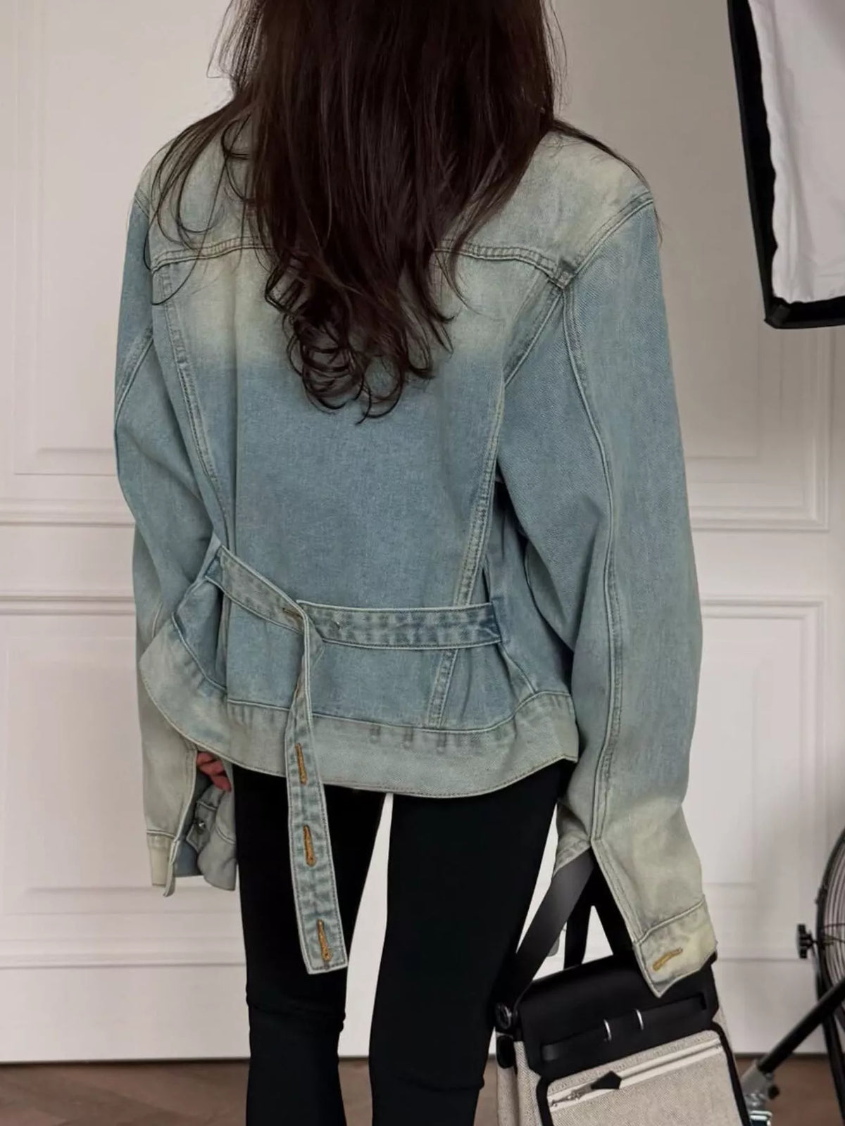 Light blue washed belted denim jacket, back view belted.