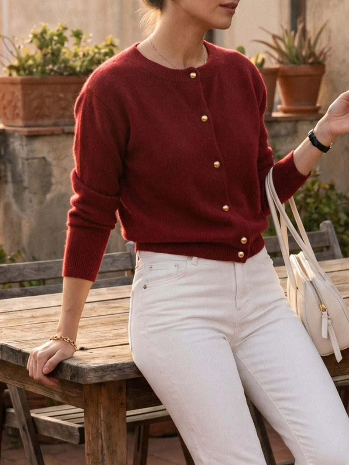 Burgundy round-neck button-front knit cardigan, angled front view.