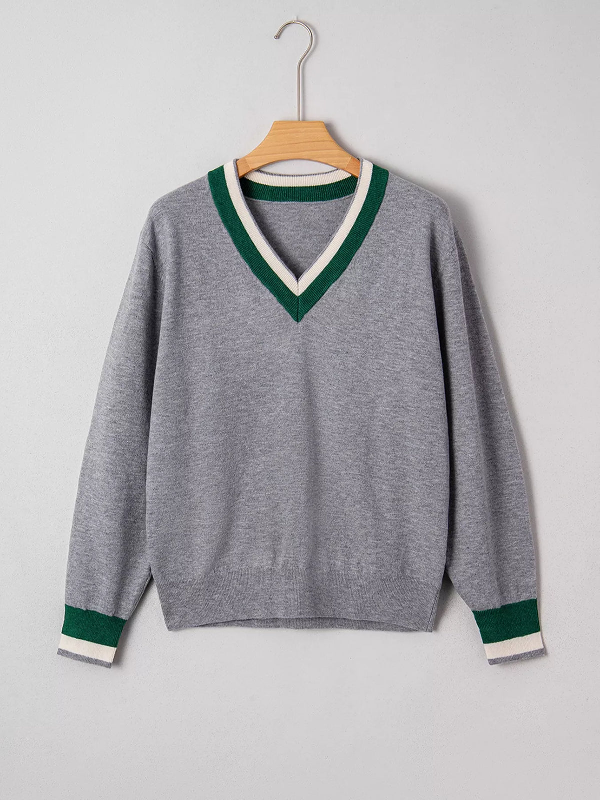 Gray v-neck sweater with striped trim, front on hanger.