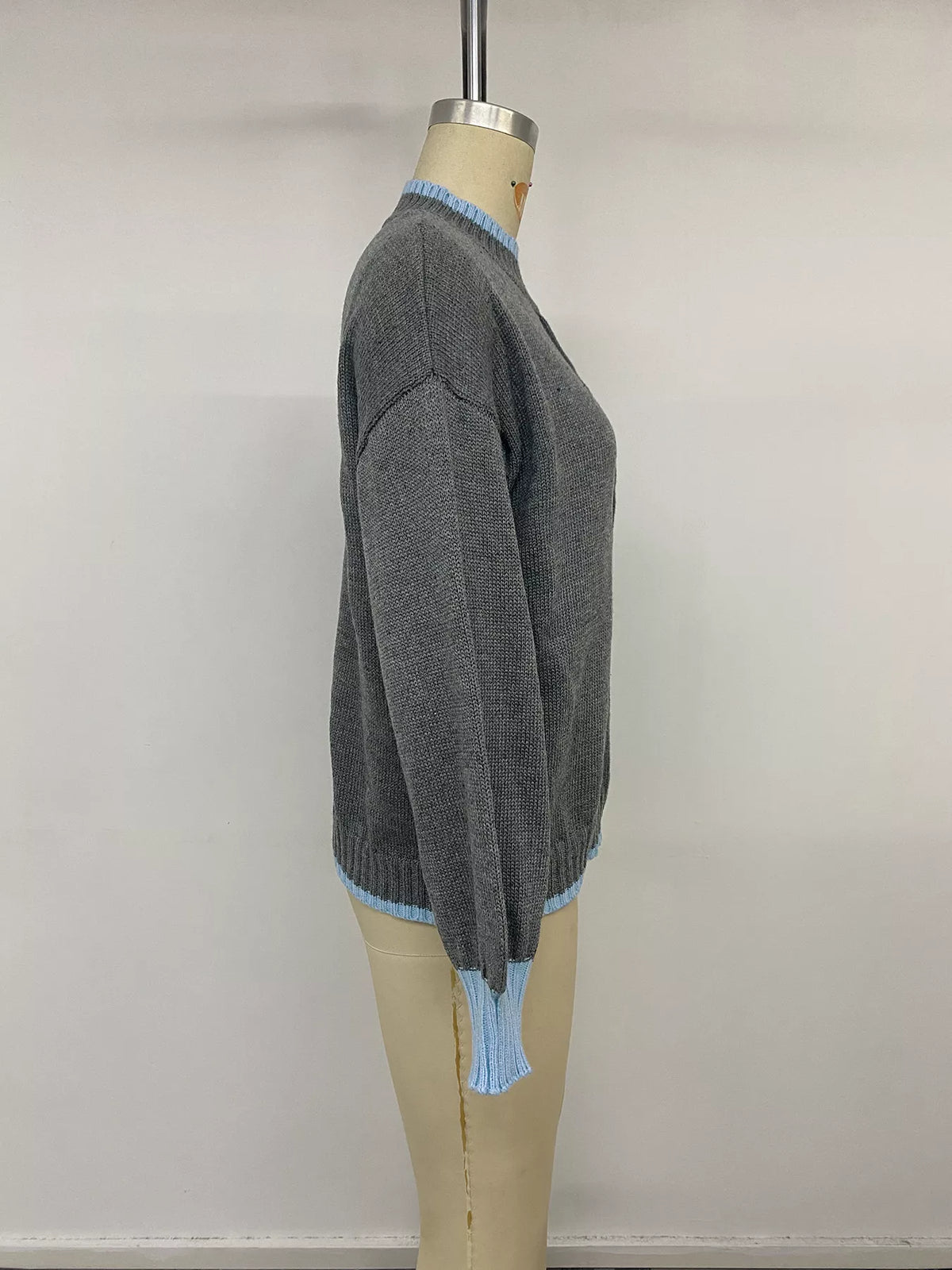 Gray sweater with blue contrast trim, side on mannequin