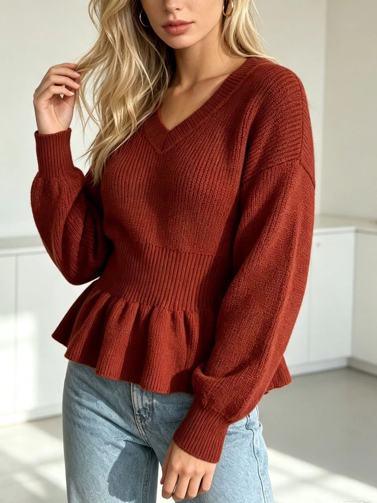 Rust v-neck peplum-hem knit sweater, angled front view.