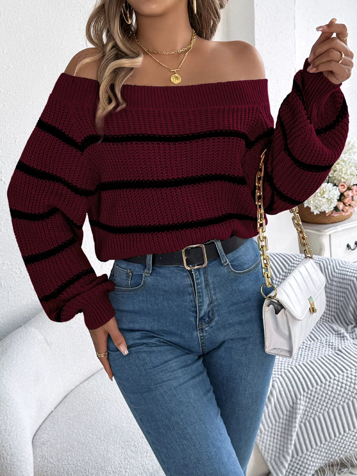 Burgundy off-shoulder striped sweater, front with raised hand.