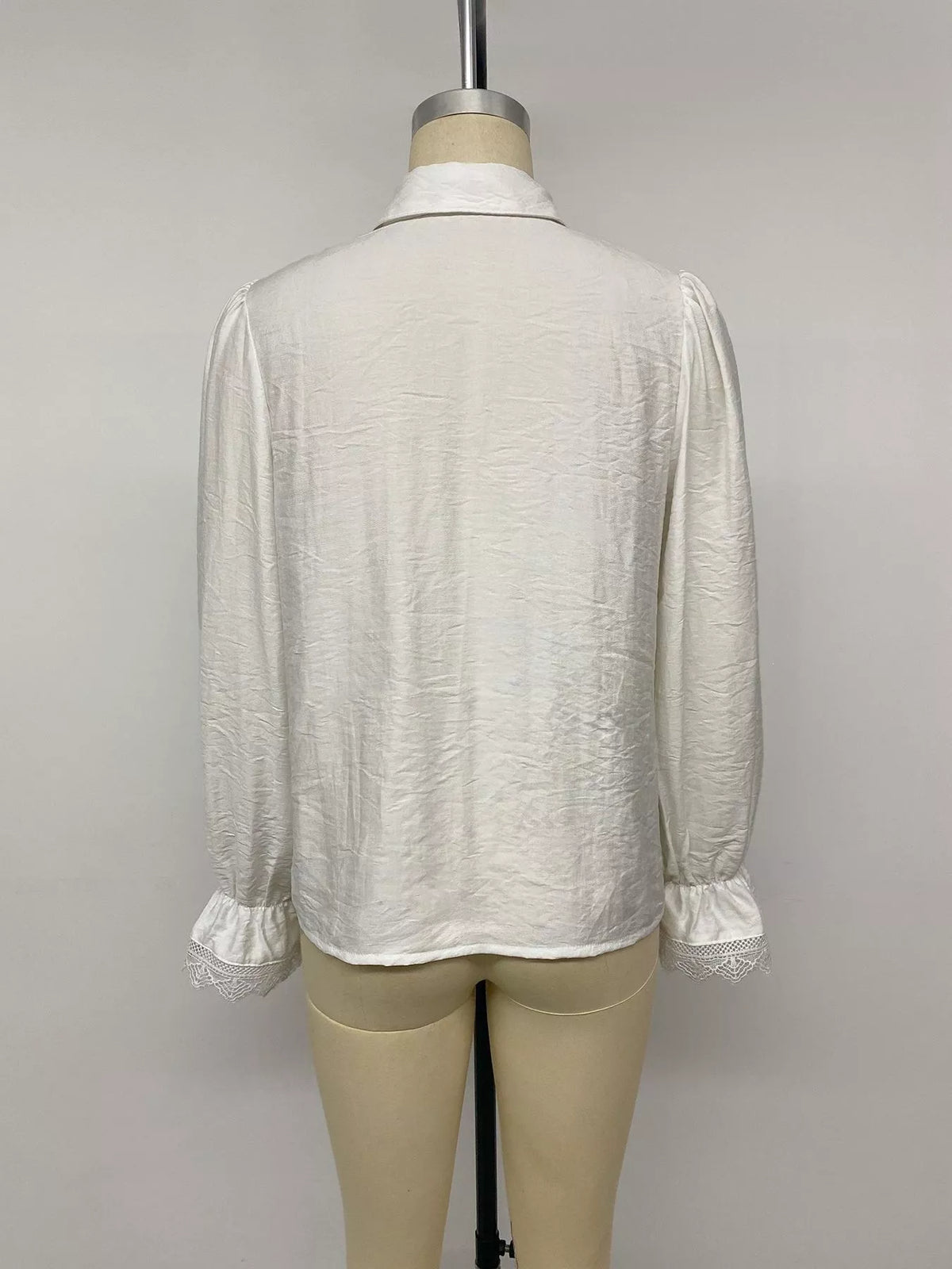 White lace-trimmed button-down shirt, back on mannequin