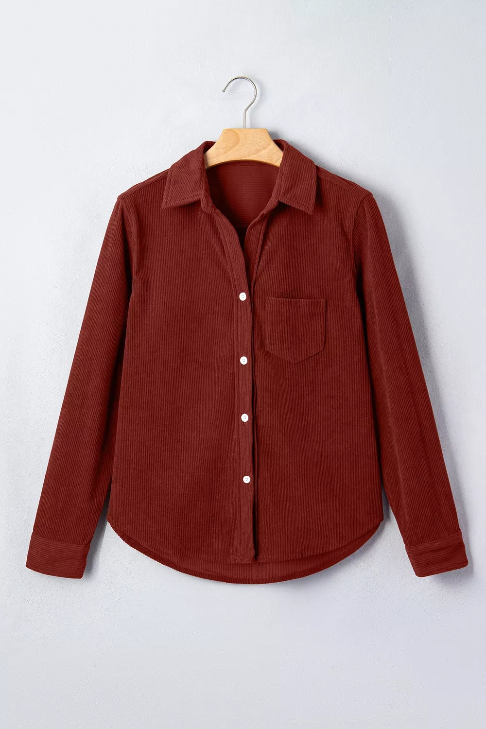 Rust corduroy button-down shirt, front on hanger