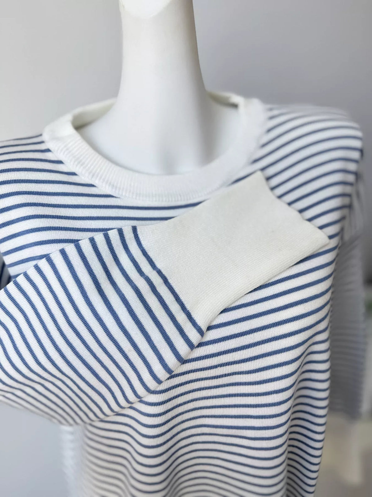 Striped round-neck knit top in white and blue, folded cuff detail