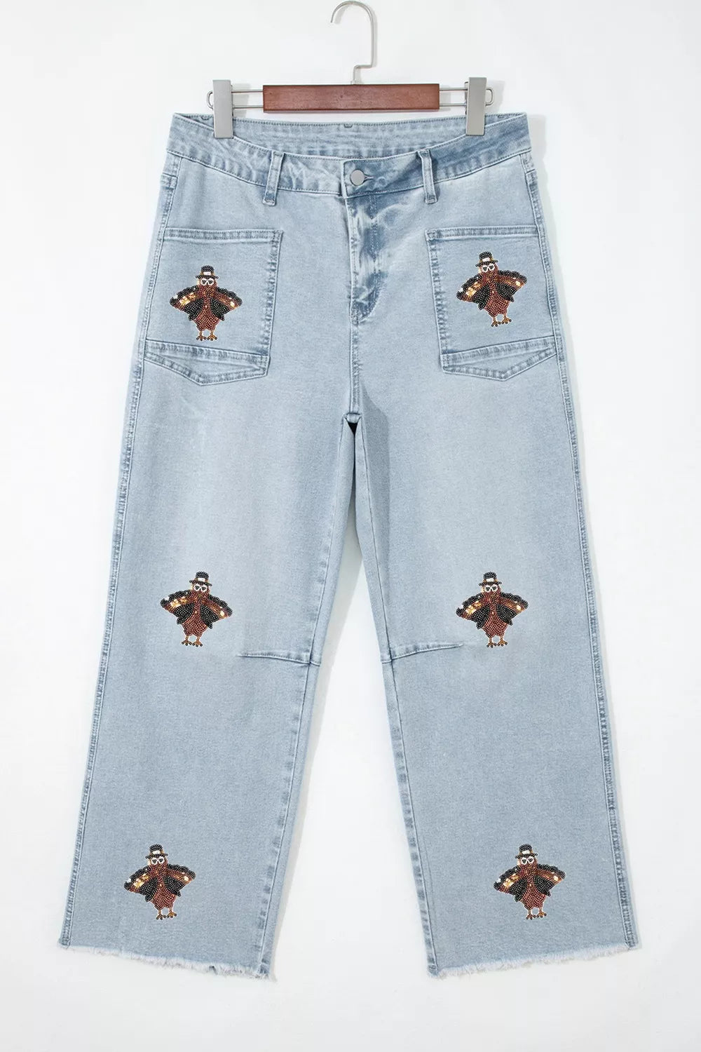 Light blue sequin turkey raw-hem ankle jeans, front on hanger.