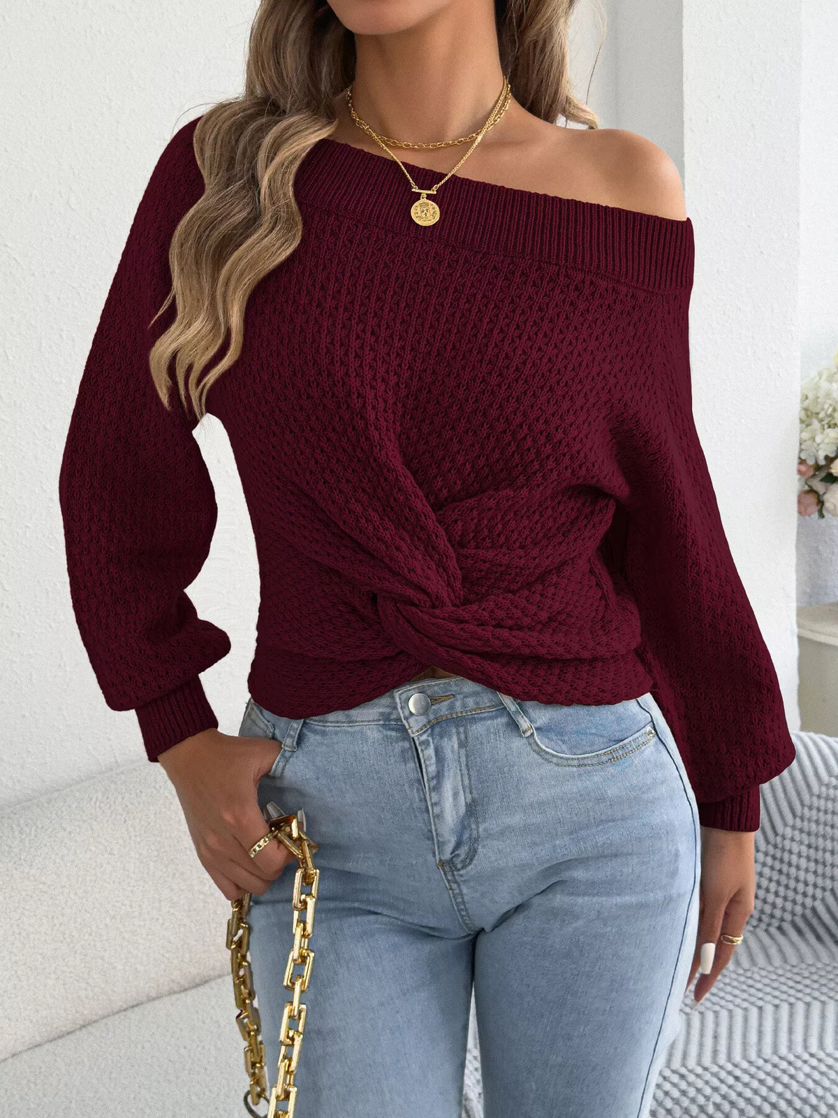 Burgundy off-shoulder twist-front knit sweater, front view showing twisted hem.
