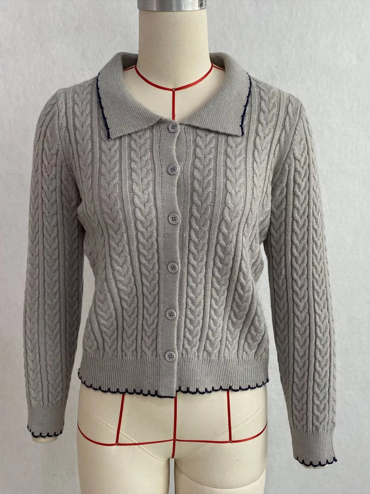 Gray cable-knit polo-collar cardigan, front on dress form.
