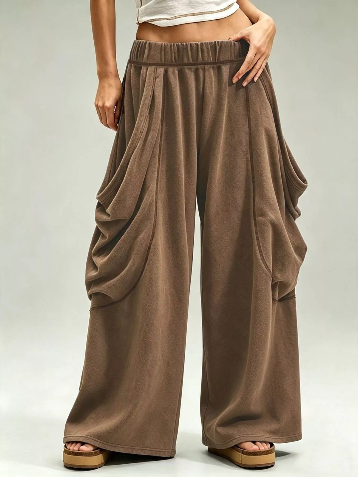 Brown wide-leg cargo pants, front view with hand at hip