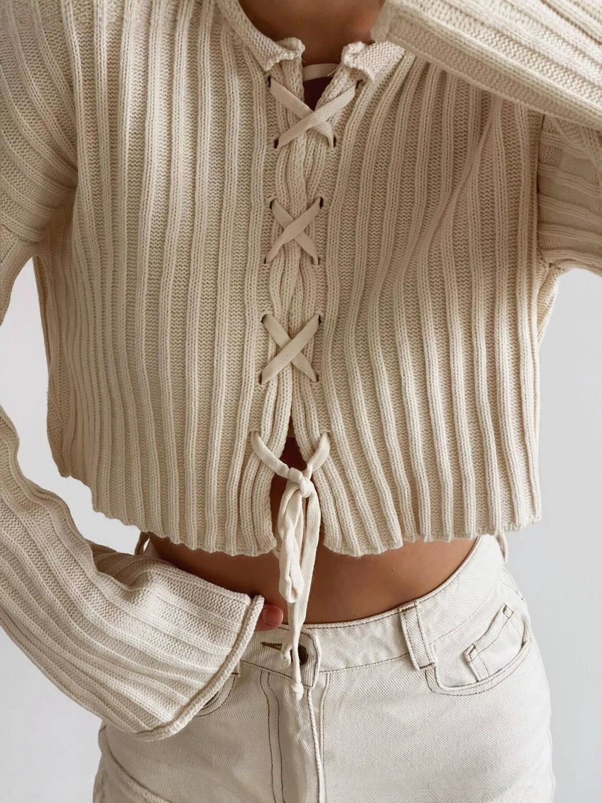 Ivory ribbed lace-up cropped sweater, lace-up front detail.
