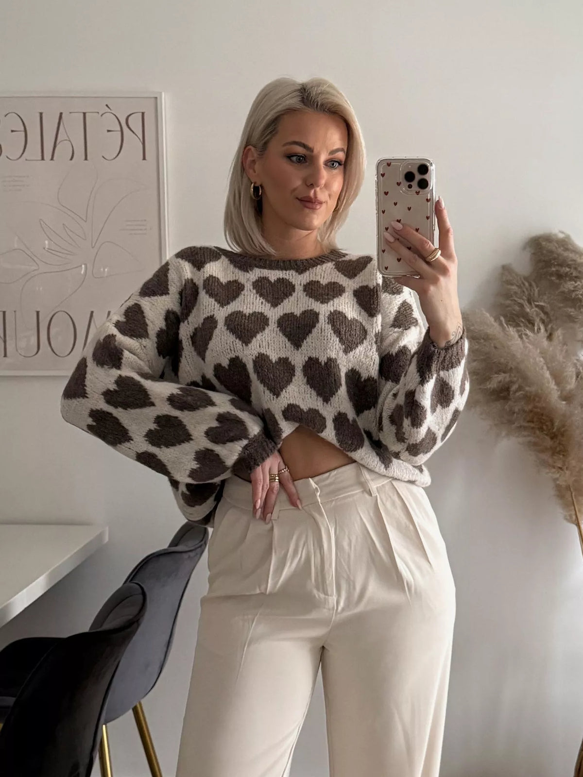 Cream and brown allover heart dropped-shoulder sweater, front partially tucked.