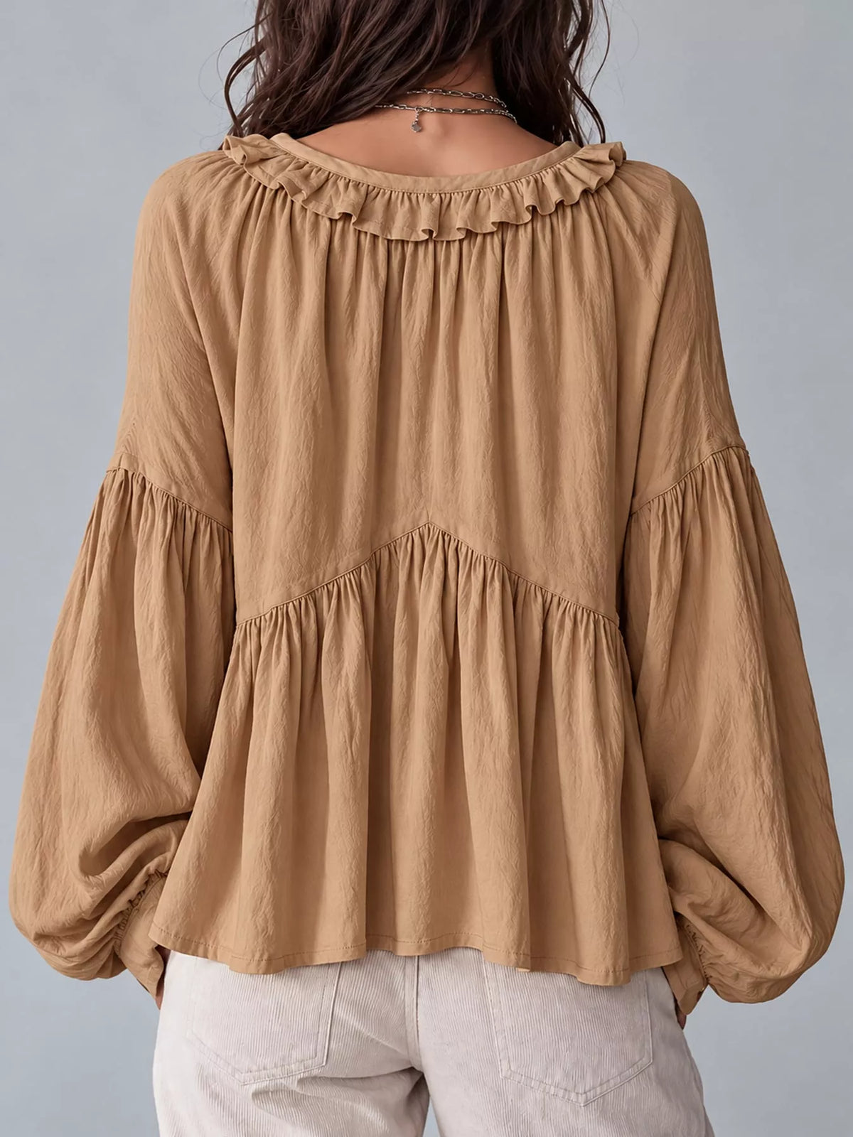 Tan ruffled v neck blouse, back view