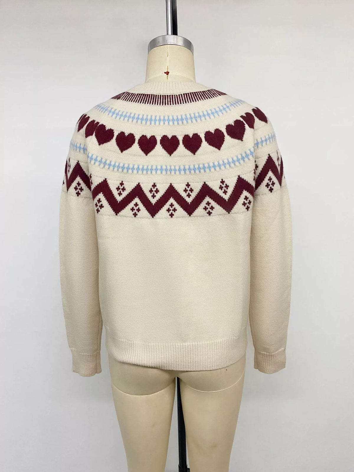 Cream heart-patterned crew neck sweater, back on mannequin