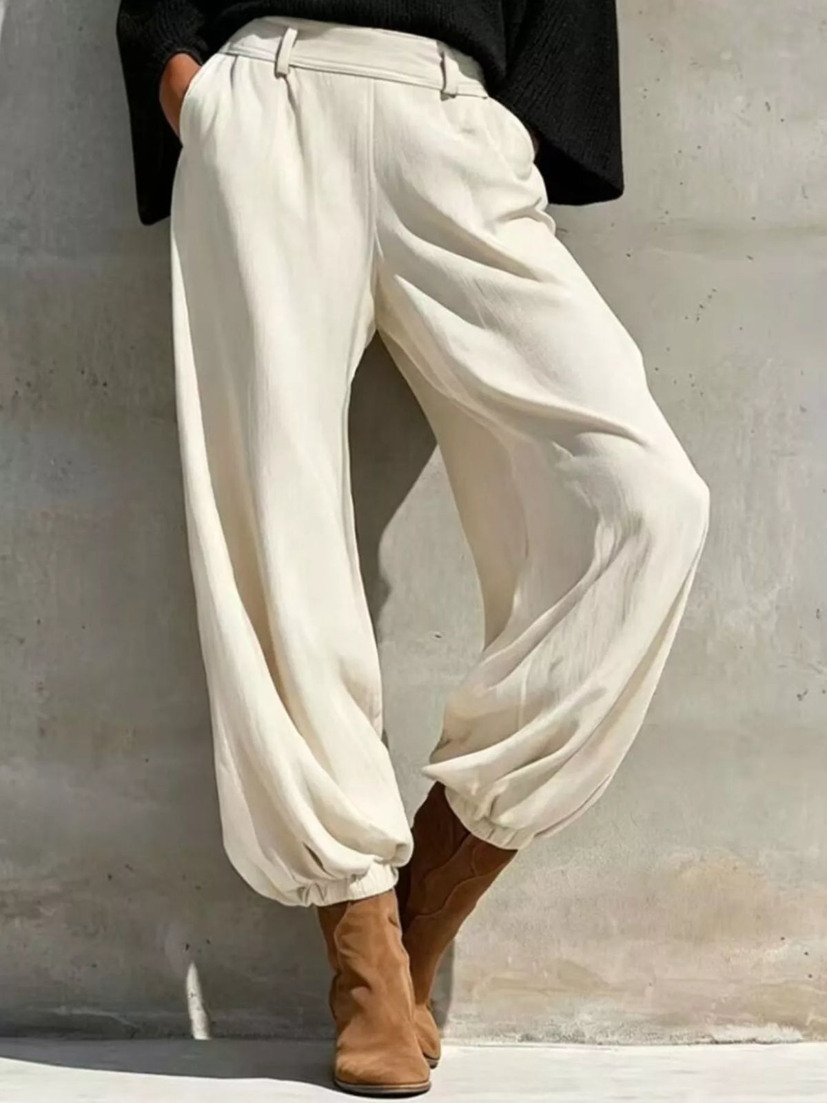 Black one-shoulder knit top and pants set, white pants front view.