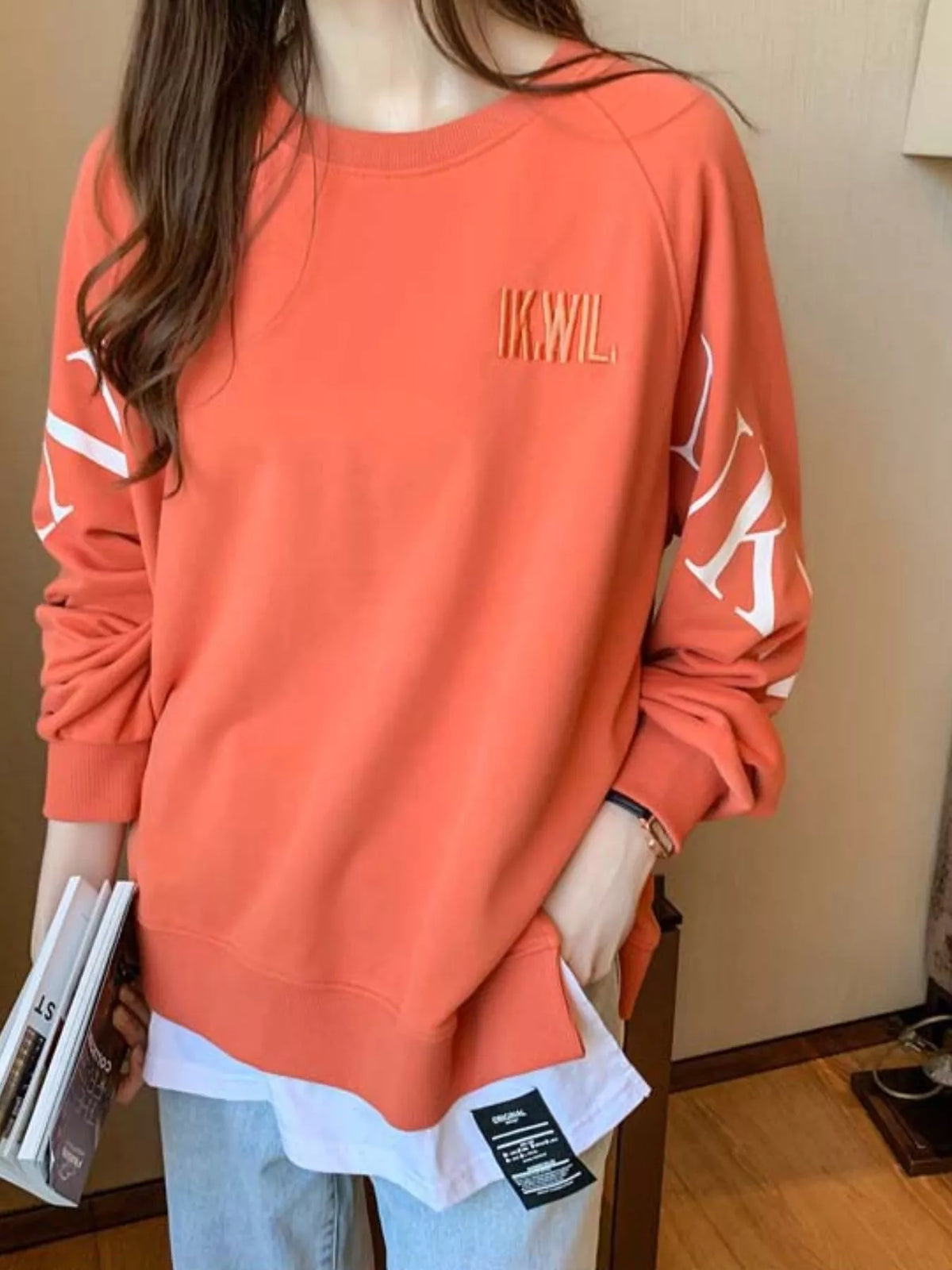 Orange layered-hem sweatshirt with graphic sleeve detail