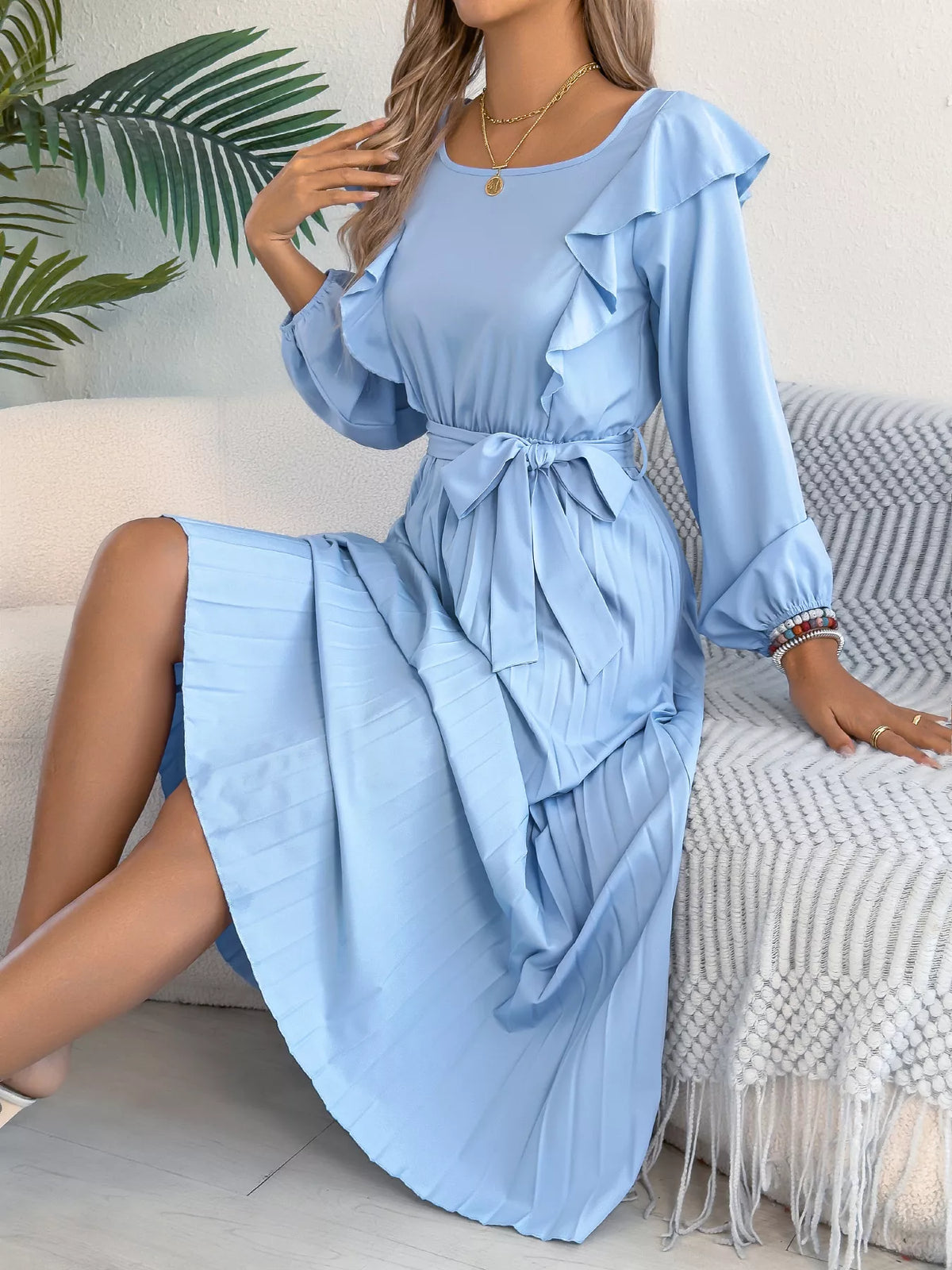 Blue ruffled pleated tie-waist midi dress, seated front view.