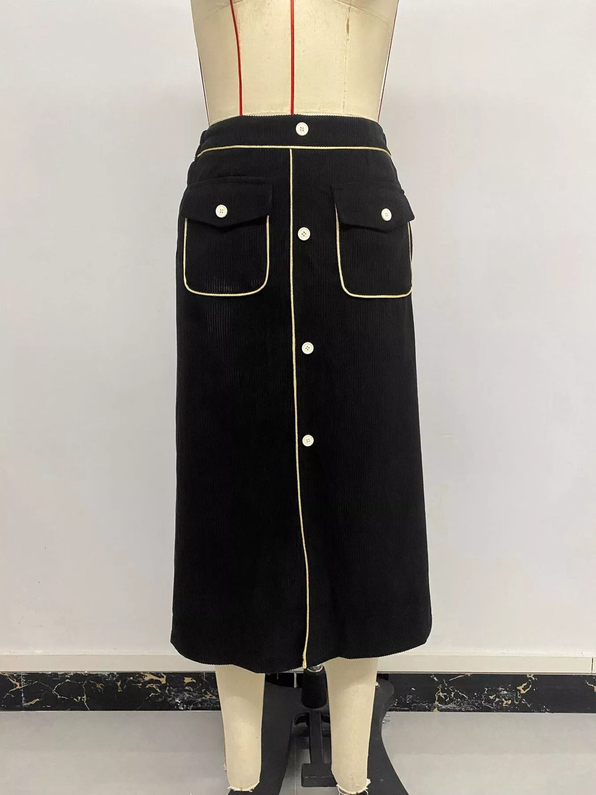 Black corduroy button-front midi skirt, front on mannequin